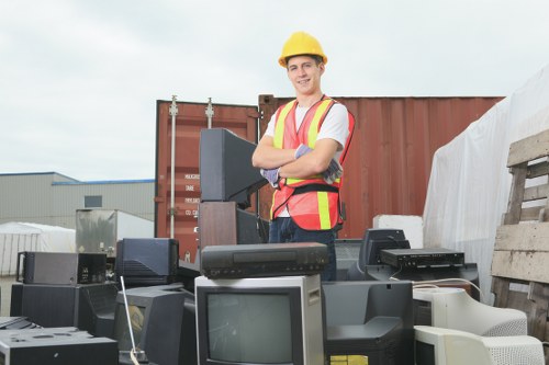 Operator loading commercial waste with hi-visibility clothing and gloves
